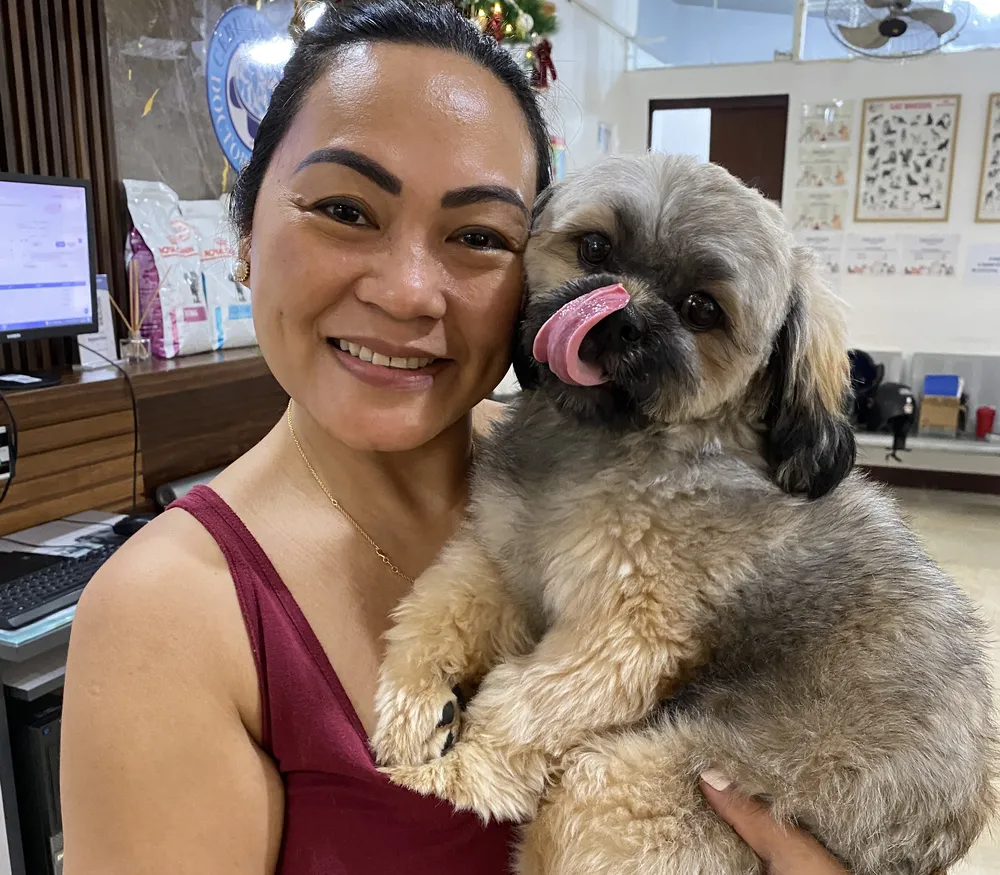 A client hugging her shih tzu at our Banilad front desk